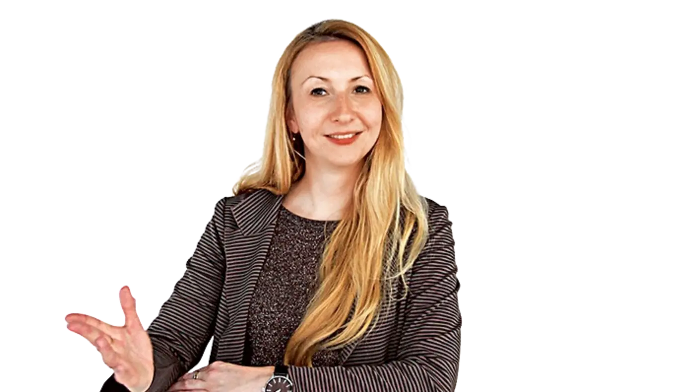 Annina Thille am Tisch sitzend und schaut mit einem Lächeln in die Kamera.