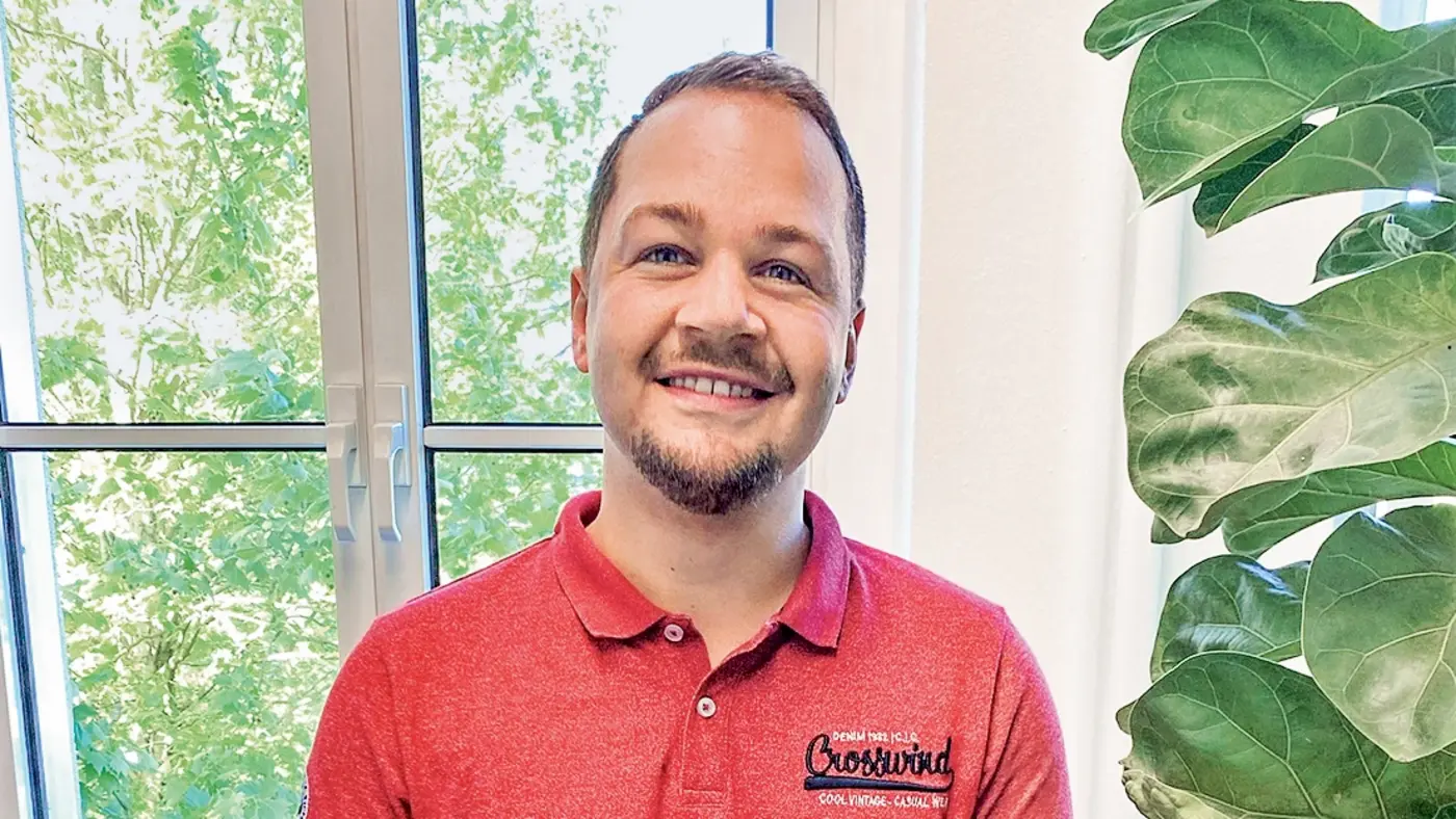Daniel Schmidthaus schaut grinsend in die Kamera.