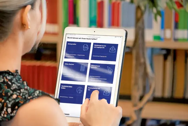 Eine Dame schaut auf Ihrem Tablet, die Online-Services der DRV.