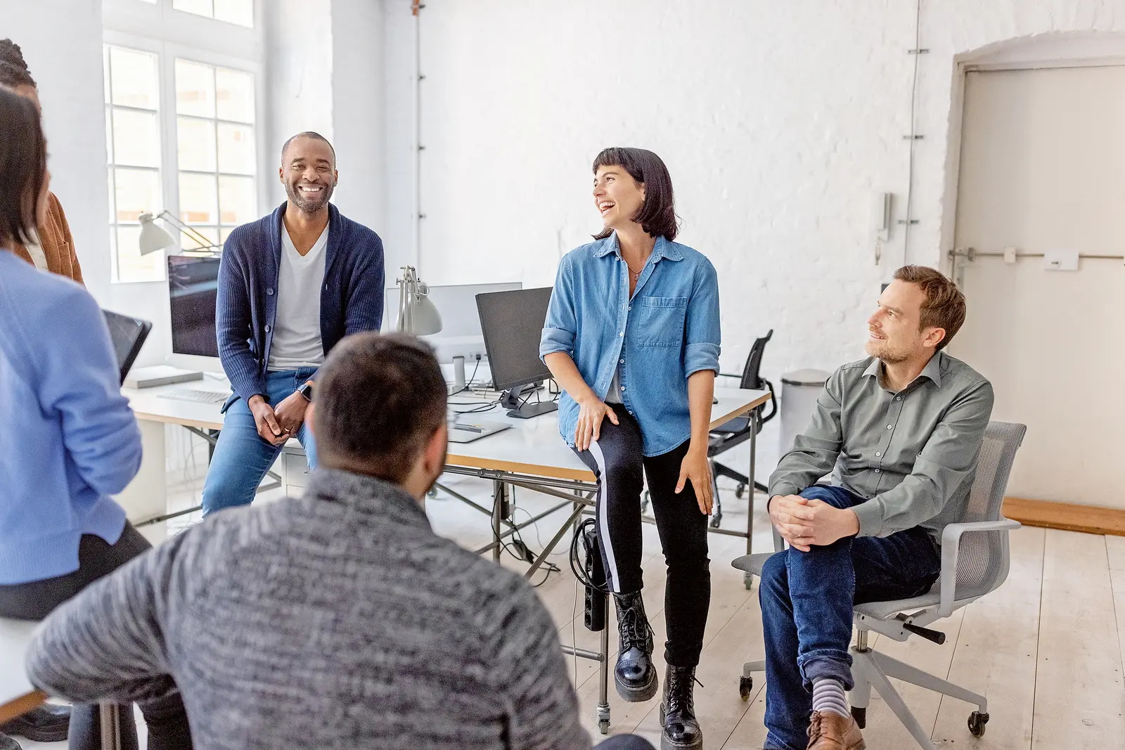 Ein Gruppengespräch zwischen Bürokolleginnen.
