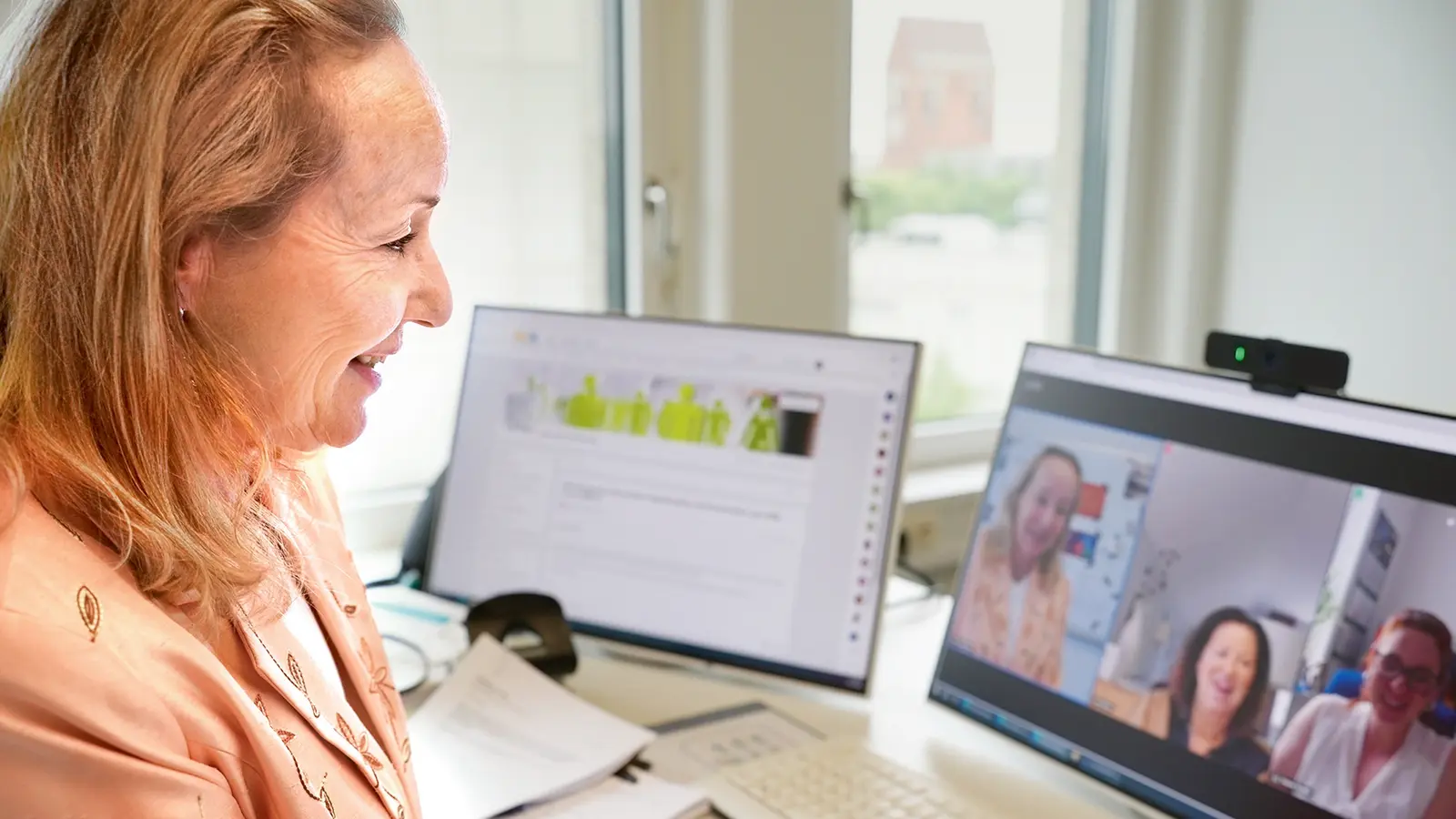 Eine Dame sitzt an Ihrem Arbeitstisch und führt ein Meeting.