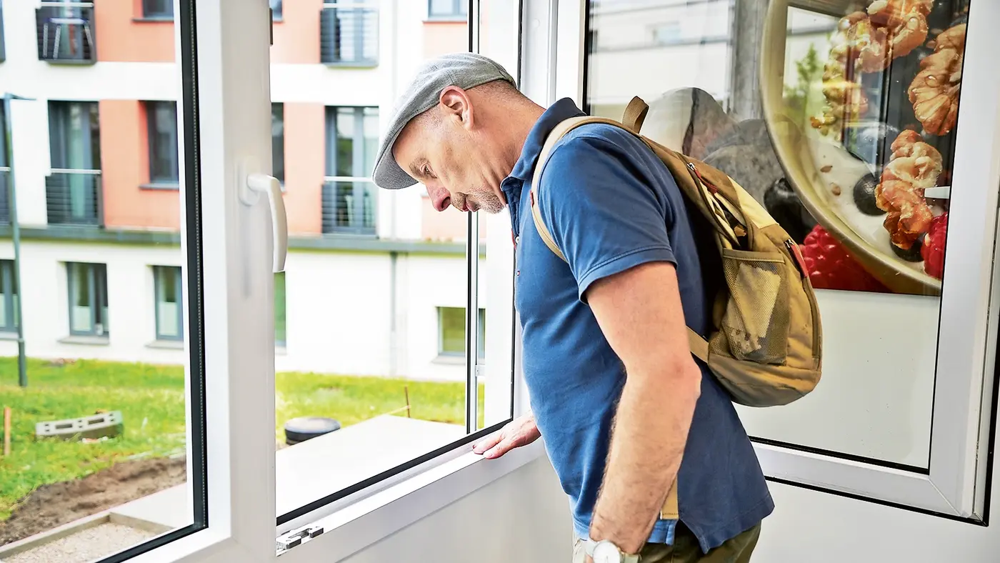 Geoffrey Payne untersucht ein Fenster auf Mängel. 