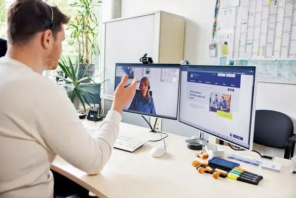 Ein Mann befindet sich an seinem Arbeitsplatz und blickt in den Monitor.
