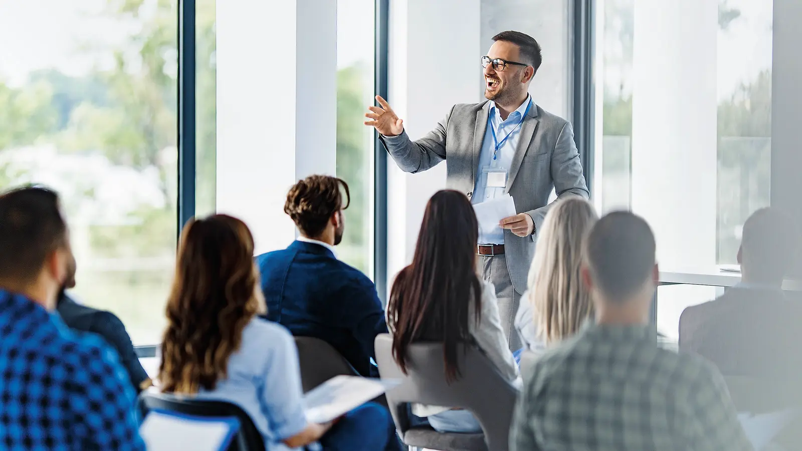 Ein Mann referiert vor einer Menschengruppe.