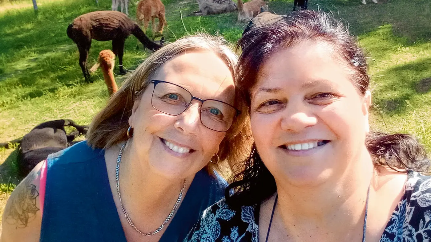 Zwei Damen machen ein Selfie in der Natur. 