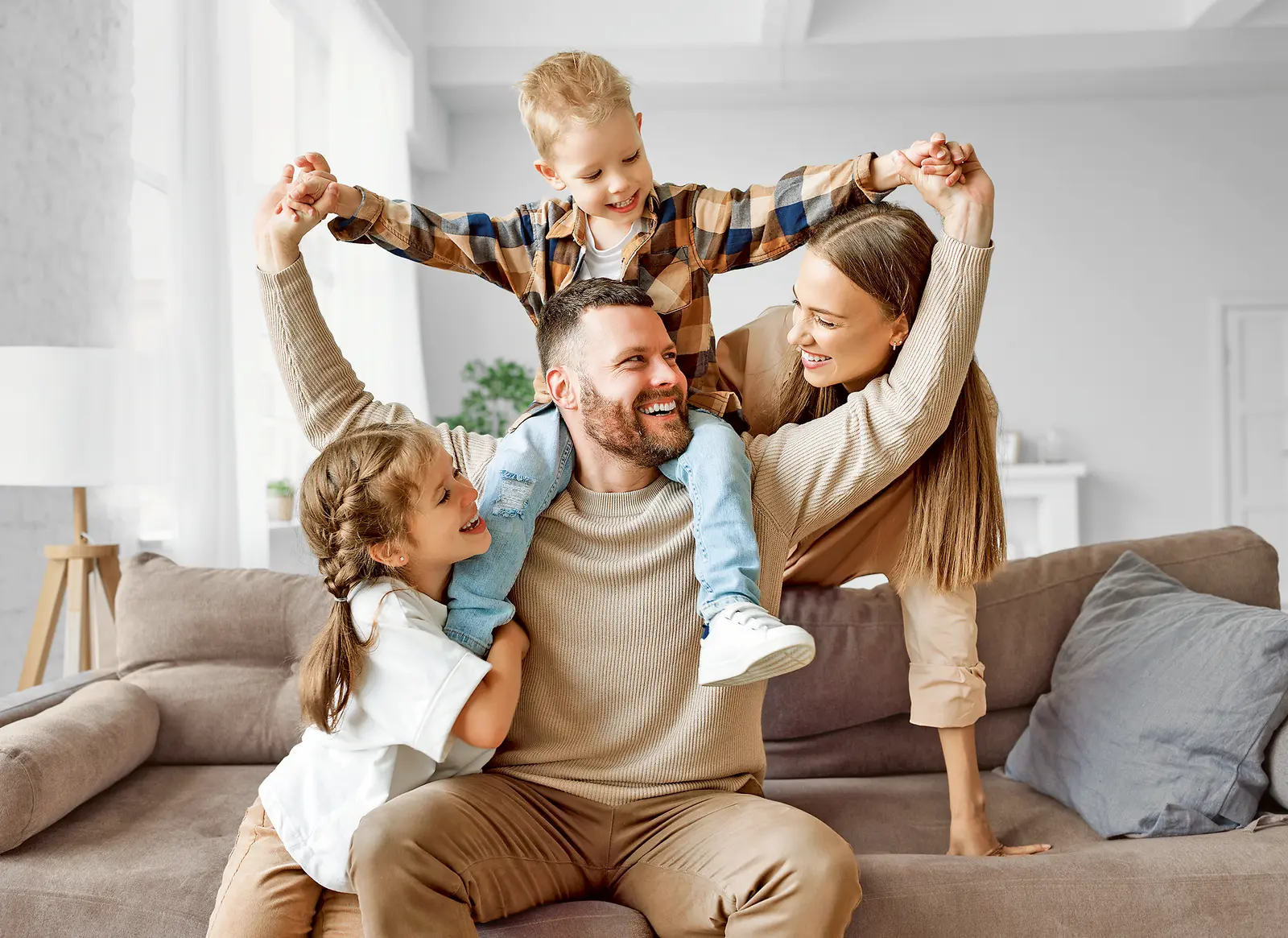Ein Familienvater spielt begeistert mit seinen drei Kindern in der Wohnung.