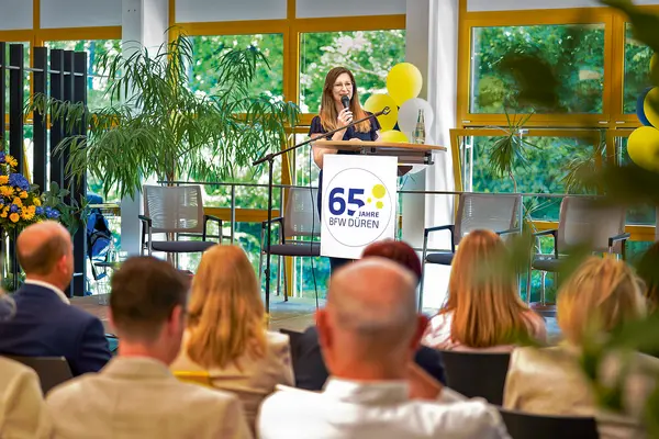Eine Sprecherin am Podest bei der Feier des Berufsförderungswerks (BFW) Düren.