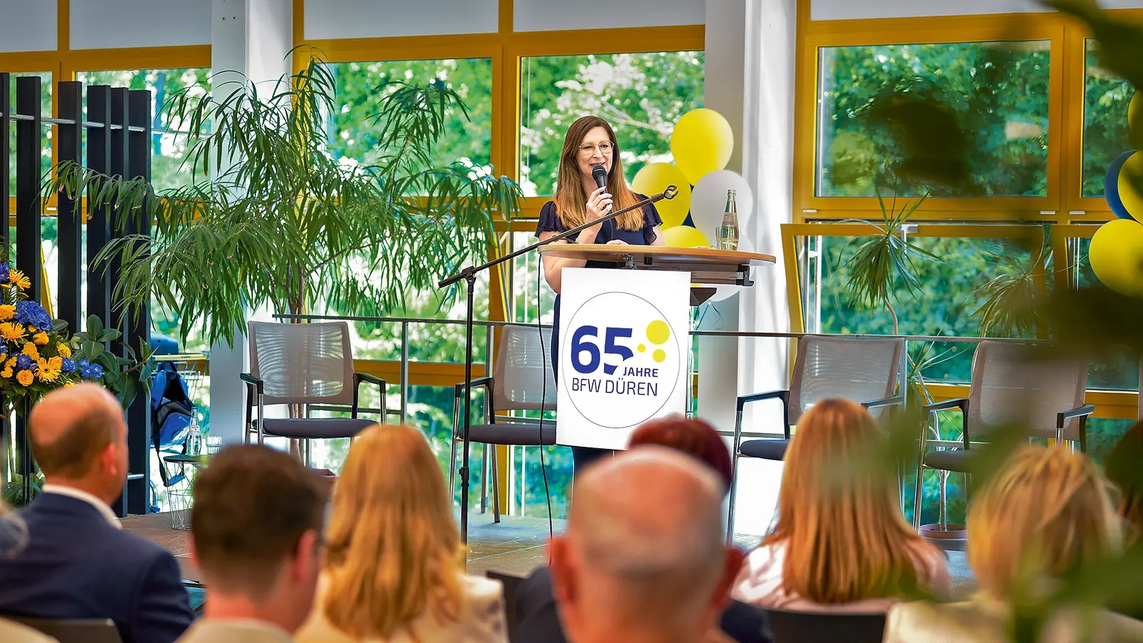 Eine Sprecherin am Podest bei der Feier des Berufsförderungswerks (BFW) Düren.