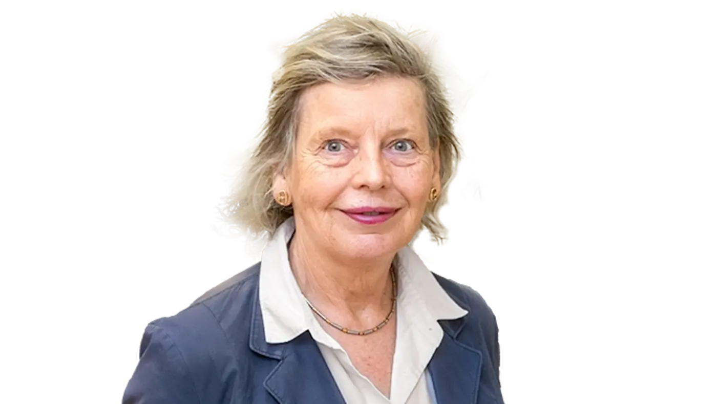 Porträt einer älteren Frau mit kurzen, graublonden Haaren. Sie trägt eine weiße Bluse mit dunklem Jackett und eine feine Halskette. Die Frau blickt freundlich in die Kamera.