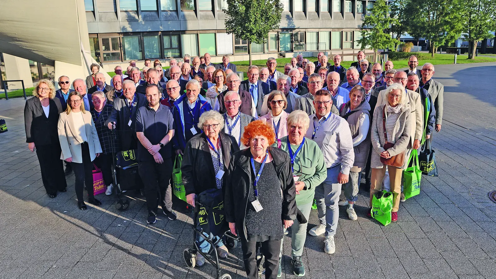 Ein Gruppenbild von Pensionären, die im Freien direkt in die Kamera blicken.
