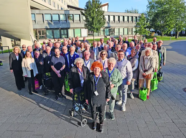 Ein Gruppenbild von Pensionären, die im Freien direkt in die Kamera blicken.