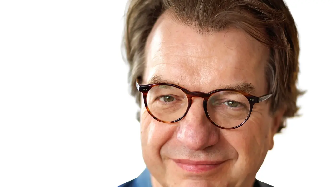 Porträt von Andreas Hoffmann mit Brille und blauem Hemd vor weißem Hintergrund.