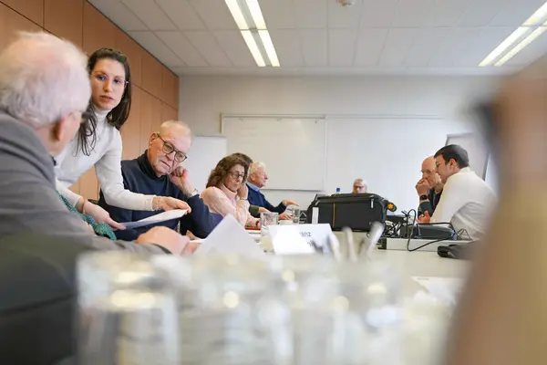 Eine Projektmitarbeiterin hilft Versichertenältesten bei aufkommenden Fragen.