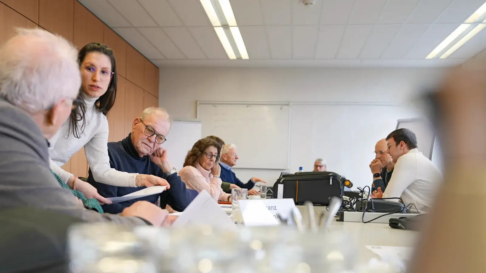 Eine Projektmitarbeiterin hilft Versichertenältesten bei aufkommenden Fragen.