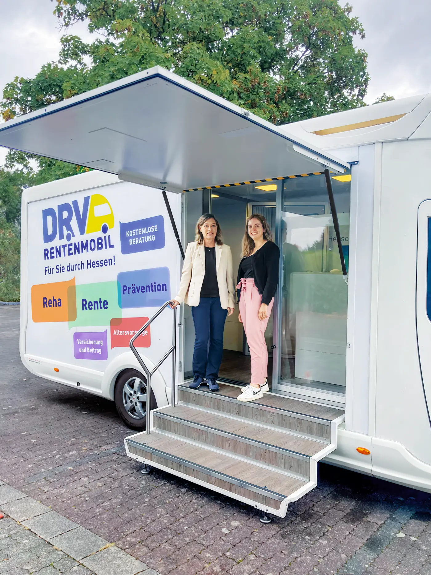 Zwei Frauen stehen vor dem Rentenmobil der DRV.