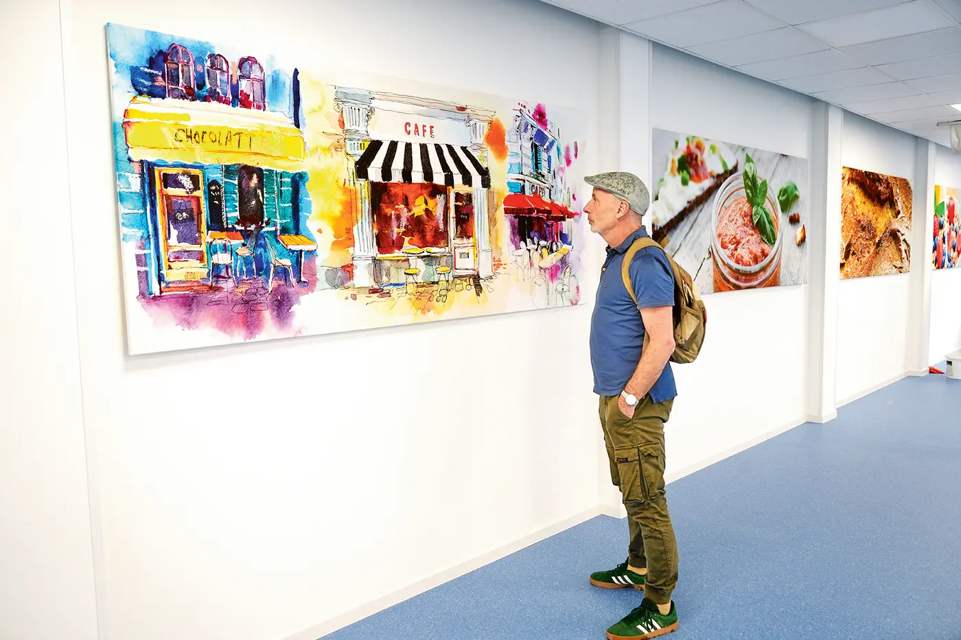 Geoffrey Payne schaut sich ein Gemälde an der Wand an. 